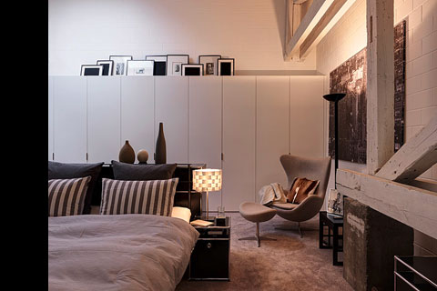 bedroom, white wall closet, black framed pictures on top of the closet, duvet cover, grey-striped cushions