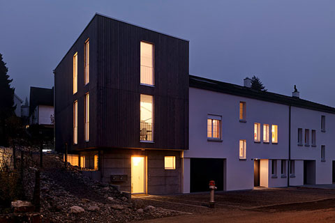 facade of the modern cubic house at night, lighted windows